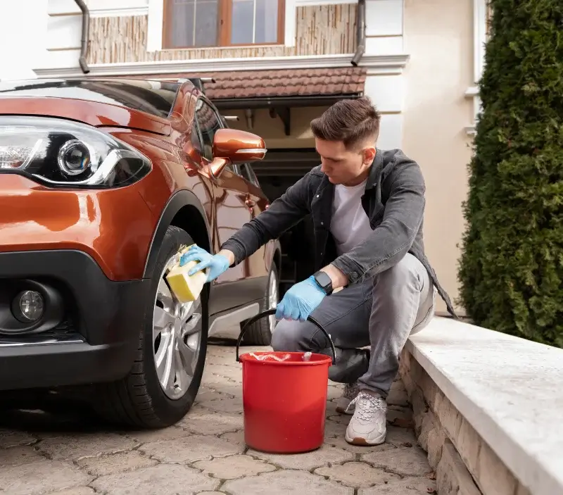 Lavage auto à domicile La Plaine : professionnel intervenant sur un véhicule